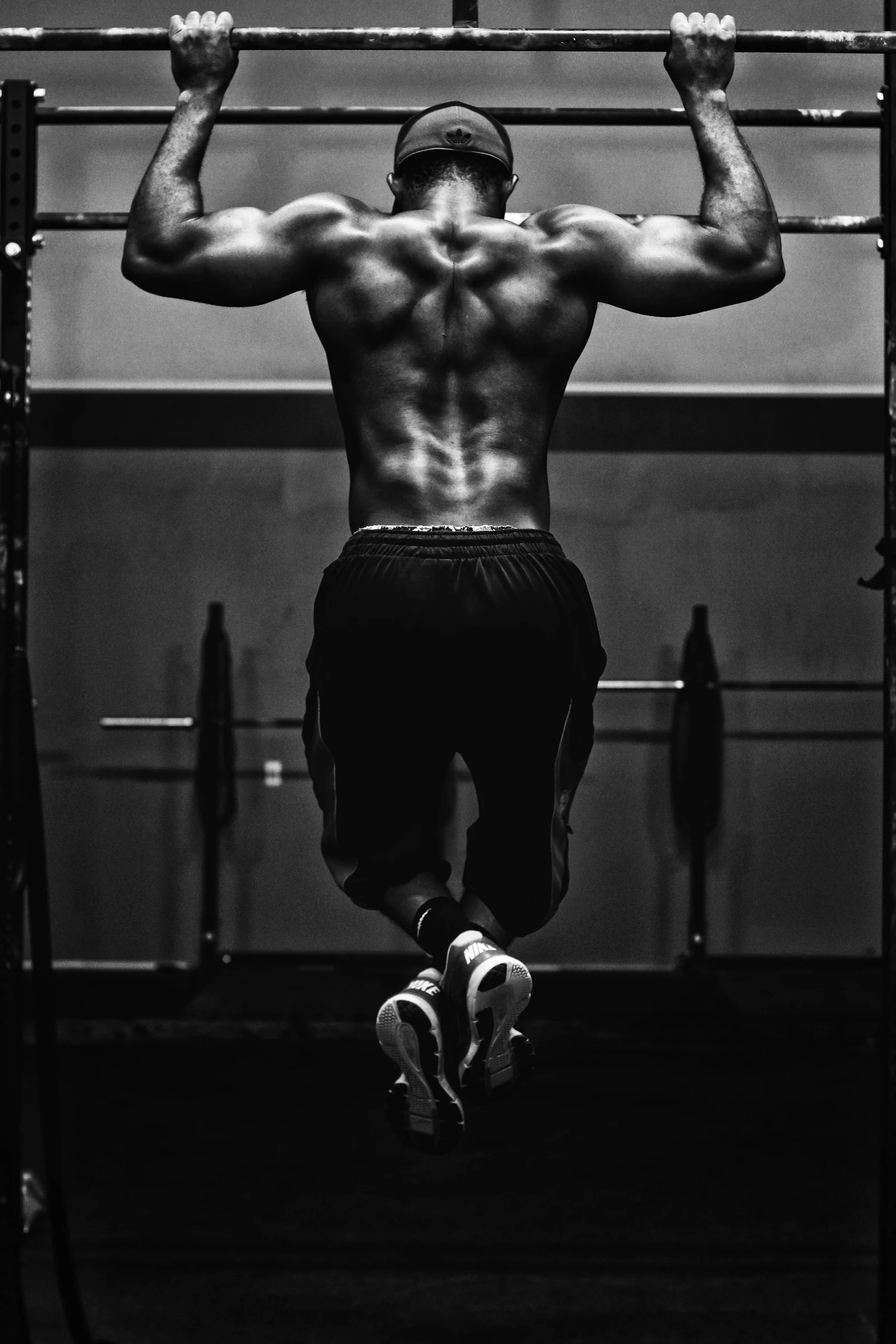 Athlete pressing a loaded barbell under low gym lighting